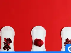 Trzy podpaski na czerwonym tle. Na dwóch są czerwone serduszka, na jednej skrzepy. Obfite miesiączki skrzepy po 40. mogą być powodem do niepokoju.
